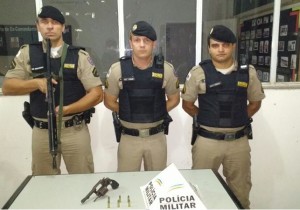 Policiais com a arma e munições apreendidas com um dos suspeitos